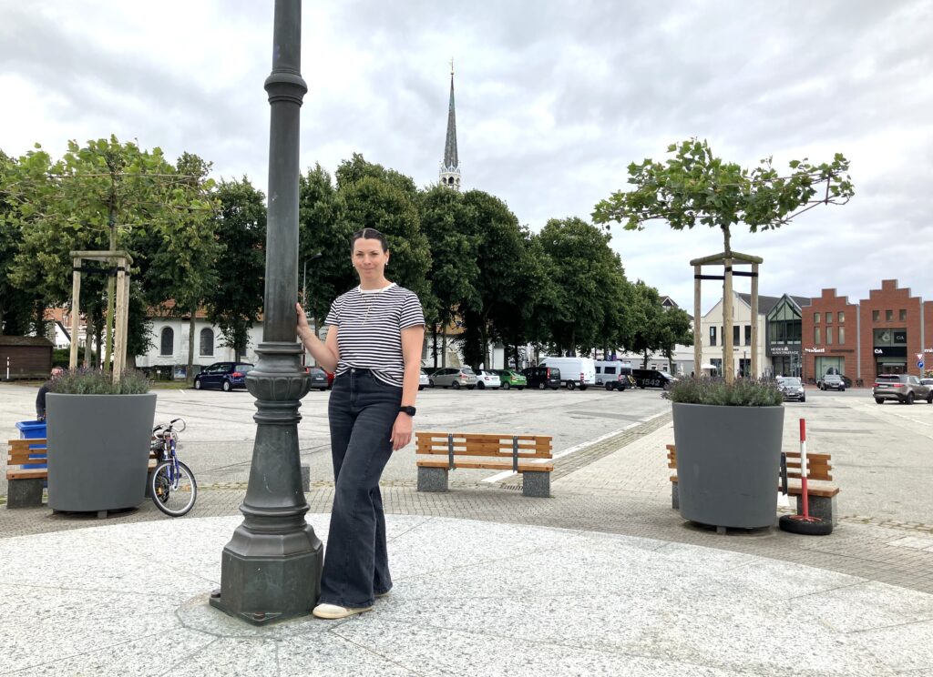 Die neue Marktmeisterin Sabrina Gans steht zentral auf dem Rondell auf dem Heider Marktplatz